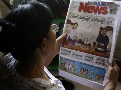 ေဒၚေအာင္ဆန္းစုၾကည္ ႏွင့္ စစ္အစိုးရ၏ ဆက္ဆံေရးကို ျပည္သူမ်ားက စိတ္၀င္စားမႈျမင့္တက္လာရာပံုတြင္ အပတ္စဥ္ထုတ္ျမန္မာ ဂ်ာနယ္တစ္ေစာင္၌ ဆက္ဆံေရး၀န္ႀကီး ႏွင့္ သူမ တို ့ေတြ ့ဆံုပံုကို စိတ္၀င္စားစြာဖတ္ရႈေနသူ တစ္ဦး (AP Photo/Khin Maung Win)